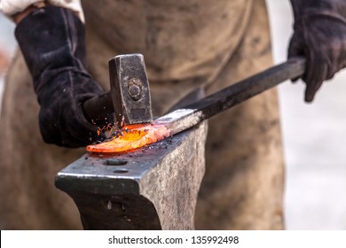 Blacksmith working on metal on anvil at forge high speed detail shot