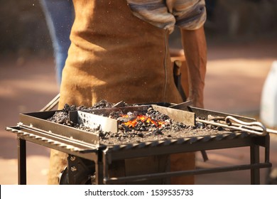 Blacksmiths forge horseshoes. Heated metal for forging according to the ancient method. An old blast furnace. Workshop horse harness manufacturing forged implements. Masters at the Fire Furnace - Powered by Shutterstock