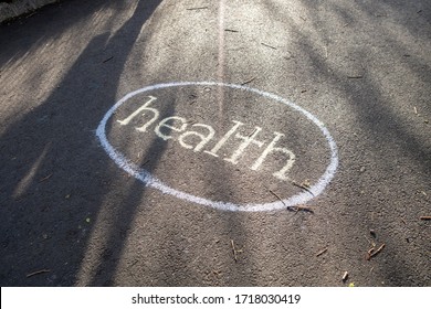 Blacktop Tarmac Street With The Word Health Written In White Choke Around A Circle