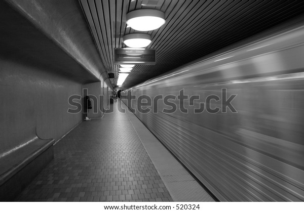 A black/white\
image of a subway car flying by. Extra grain is added for an urban\
gritty feel to the image.