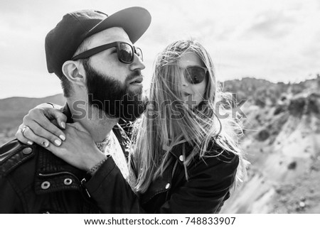 Black&white photo of happy couple in love stand and hug on the mountain's road