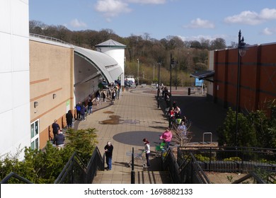 BLACKWOOD, WALES, UK - APRIL 6th 2020: Shoppers In A Long Queue For An ASDA Supermarket Across A Public Square In South Wales During The Coronavirus Pandemic (elevated View)