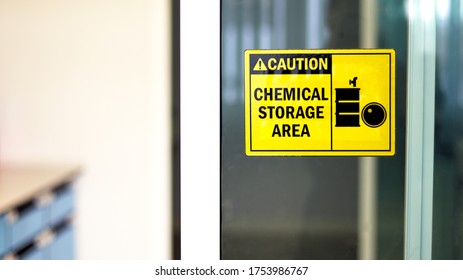 Black-yellow Chemical Storage Area Hazard Sign And Symbol On The Glass Door, Caution For Warning Dangerous Space In Laboratory Room. Selective Focus On Tag, Blurred Background Safety First Concept.