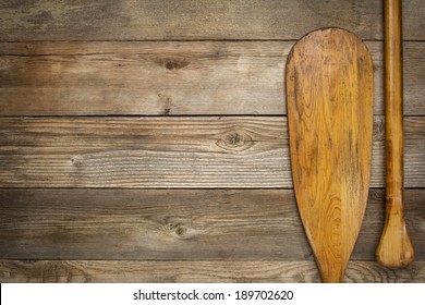 Blade And Grip Of Wooden Canoe Paddle Against A Wood Background With A Copy Space