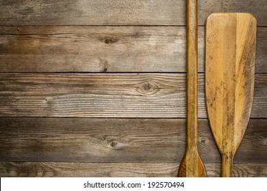 Blade And Grip Of Wooden Canoe Paddle Against Rustic Wood Background With A Copy Space