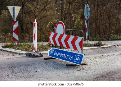 Blagoevgrad, BULGARIA - 14 November 2015: Construction workers carrying out repairs of the road in the highlands. Detour road sign. Road Closed