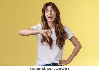Blah Blah Boring. Unimpressed Apathetic Snobbish Attractive Curly-haired Girl Look Away Express Scorn Disdain Show Thumb Down Frowning Sharing Negative Judgement Bad Opinion Yellow Background
