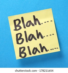 Blah, Blah, Blah written in black felt tip on a yellow sticky note on a blue background. A concept image for worthless communication and talking nonsense.
