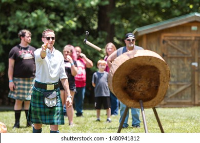 Blairsville, GA / USA - June 9 2018:  A Man Throws A Hatchet At Wood Target In An Axe Throwing Exhibition  At The Blairsville Scottish Highland Games At Meeks Park On June 9, 2018 In Blairsville, GA.