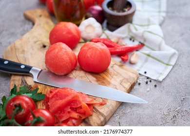 blanched peeled tomatoes on wooden cutting board at domestic kitchen - Shutterstock ID 2176974377