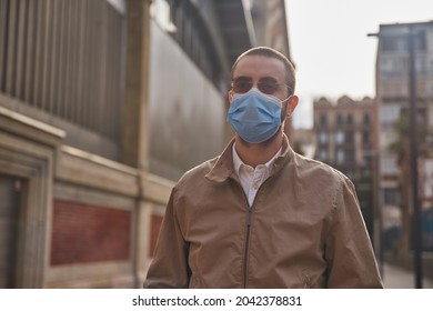 Bland Middle-aged Man Standing Next To A Building And Looking Into The Distance