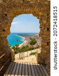 Blanes beach through a stone door of St. John Castle. Aerial panoramic view in Costa Brava in a beautiful summer day, Spain