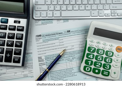 Blank 1040 US Individual income tax return form 2022 with pen calculator and computer keyboard. Deadline paperwork concept - Shutterstock ID 2280618913