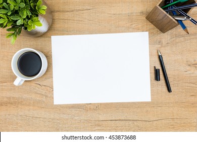 Blank A4 Paper On The Wood Desk Table With Coffee And Pen. Top View, Flat Lay.