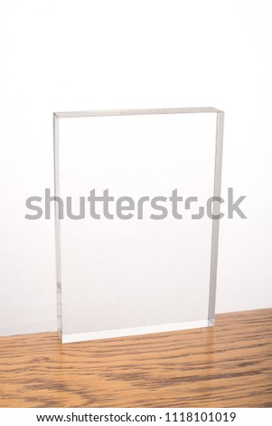 Blank acrylic block ready for engraving, rectangular shape, on wooden table