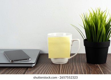 Blank adhesive note on cup of coffee with copy space
