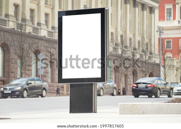 Blank advertising billboard in the city center\
next to the road. City\
format