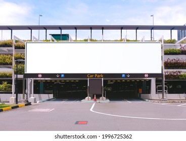 Blank advertising large billboard banner mockup, outside multi-storey carpark with eco green wall, above entrance. Large digital display screen, an out-of-home OOH media display space