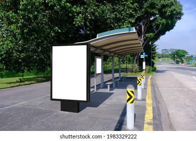Blank Advertising Poster Banner Mockup At Empty Bus Stop Shelter By Main Road, Greenery Behind; Out-of-home OOH Vertical Billboard Media Display Space. Perspective Angle