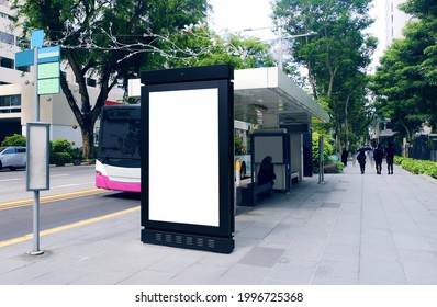 Blank advertising poster banner mockup at bus stop shelter by main road; out-of-home OOH vertical billboard media display space. Perspective angle