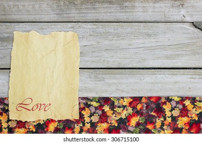 Blank antique parchment paper sign with LOVE on rustic wood background with fall decor border of colorful leaves - Powered by Shutterstock