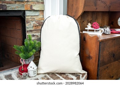 Blank beige canvas santa sack in front of fireplace, christmas gift bag mockup