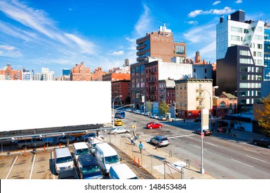 Blank Billboard In A City With High Rise Buildings And A Bright Blue Sky Overhead