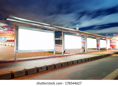 Blank billboard on bus stop at night 