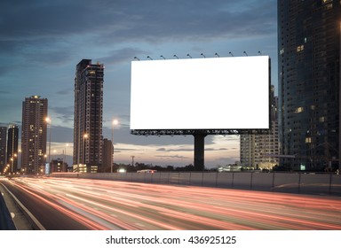 Blank billboard on the highway during the twilight with city background with clipping path on screen.- can be used for display your products or promotional