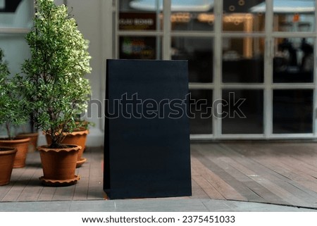 Blank black advertising frame standing mock up on floor at front of Cafe, Empty template. space for text marketing promotion.
