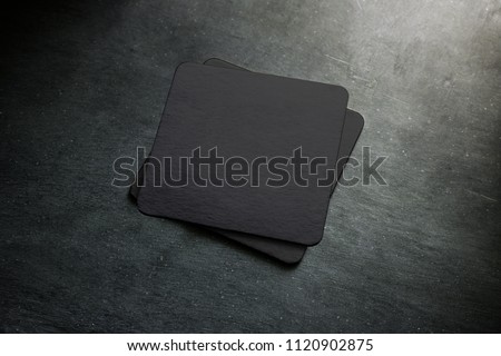 Blank black beer coaster stack mock up, top view, lying on the textured background. Squared clear can mat design mockup isolated. Quadrate cup rug display