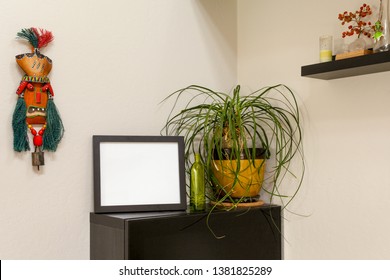 Blank Black Horizontal Picture Frame On A Shelf With A Ponytail Palm  And A Tribal Mask. For Mocking Up Photos And Artwork.