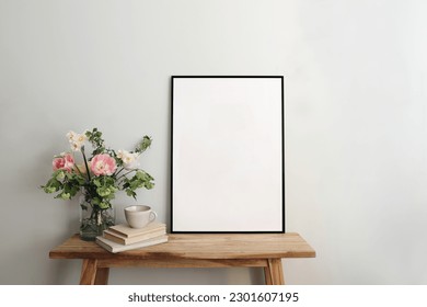 Blank black picture frame mockup. Artistic table, wooden bench still life composition with cup of coffee, old books. Spring bouquett of pink tulips, white daffodils. Hawthorn, guelder roese flowers. - Powered by Shutterstock