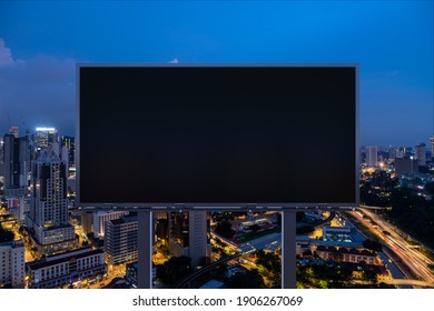 Blank black road billboard with Kuala Lumpur cityscape background at night time. Street advertising poster, mock up, 3D rendering. Front view. Concept of marketing to promote or sell idea or product. - Shutterstock ID 1906267069