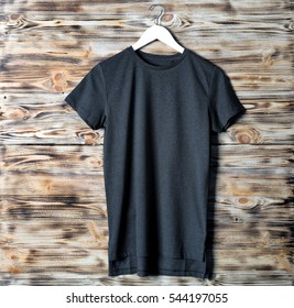 Blank black t-shirt against wooden background - Powered by Shutterstock