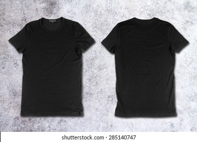 Blank black t-shirts on a concrete surface