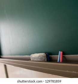 Blank Blackboard With Chalk And Eraser.