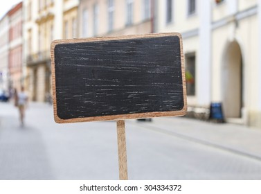 Blank blackboard label and a blurred urban landmark in the background