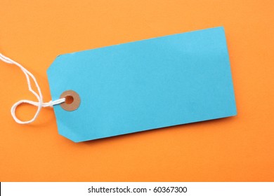 Blank Blue Paper Luggage Tag Or Label On Orange Paper Background
