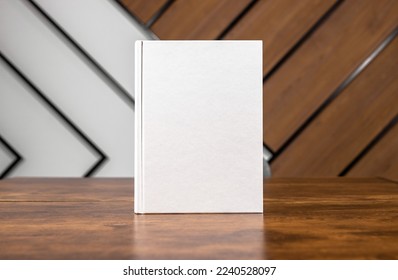 Blank book cover mockup, hardcover mock up of business literature on wood desk, office table. High quality photo