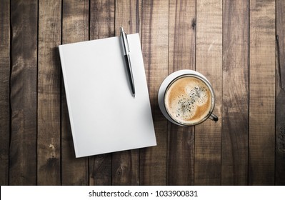 Blank Book, Pencil And Coffee Cup On Wooden Table Background. Stationery Elements. Template For Placing Your Design.