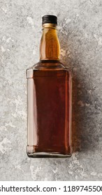 Blank Bottle With Whiskey Or Cognac On Stone Background. Self Made Label, Mockup For Trade Mark, Copy Space