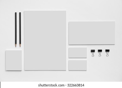 Blank branding mockup with gray business cards, envelopes and notepads isolated on white background.