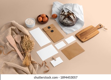 A blank branding set, featuring business cards, envelopes, cards, bread, eggs, flour, serving board, bakery branding mockup, empty space to display your logo or design.