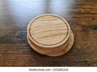 Blank Brown Coaster Stack Mockup With Wood Texture On Wooden Surface. Circular Drink Pad Pile Template