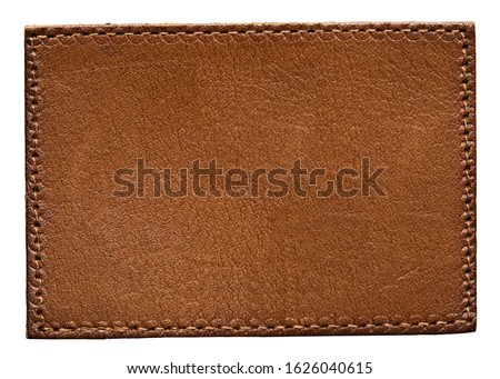 Blank brown leather label on white background, macro close up. Leather patch with stitching