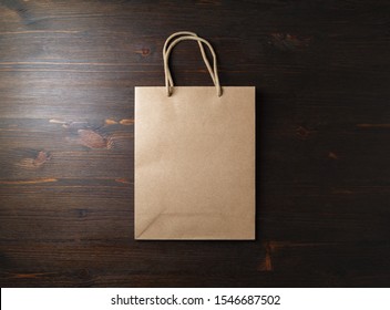 Blank Brown Paper Bag With Rope Handles On Wooden Background. Flat Lay.