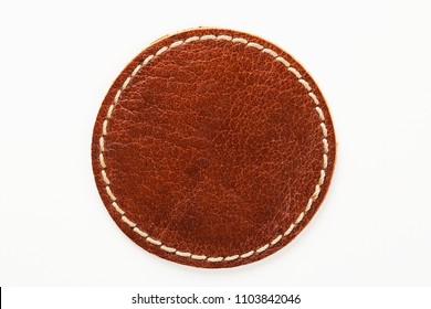 Blank brown round leather label on white background, macro close up