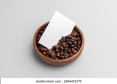 Blank business card mockup with coffee seeds wooden bowl, on white background,  coffee packaging mockup with empty space to display your branding design.