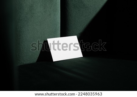 Blank business cards mockup template on a velvet, green art deco furniture, real photo. Isolated surface to place your design. 